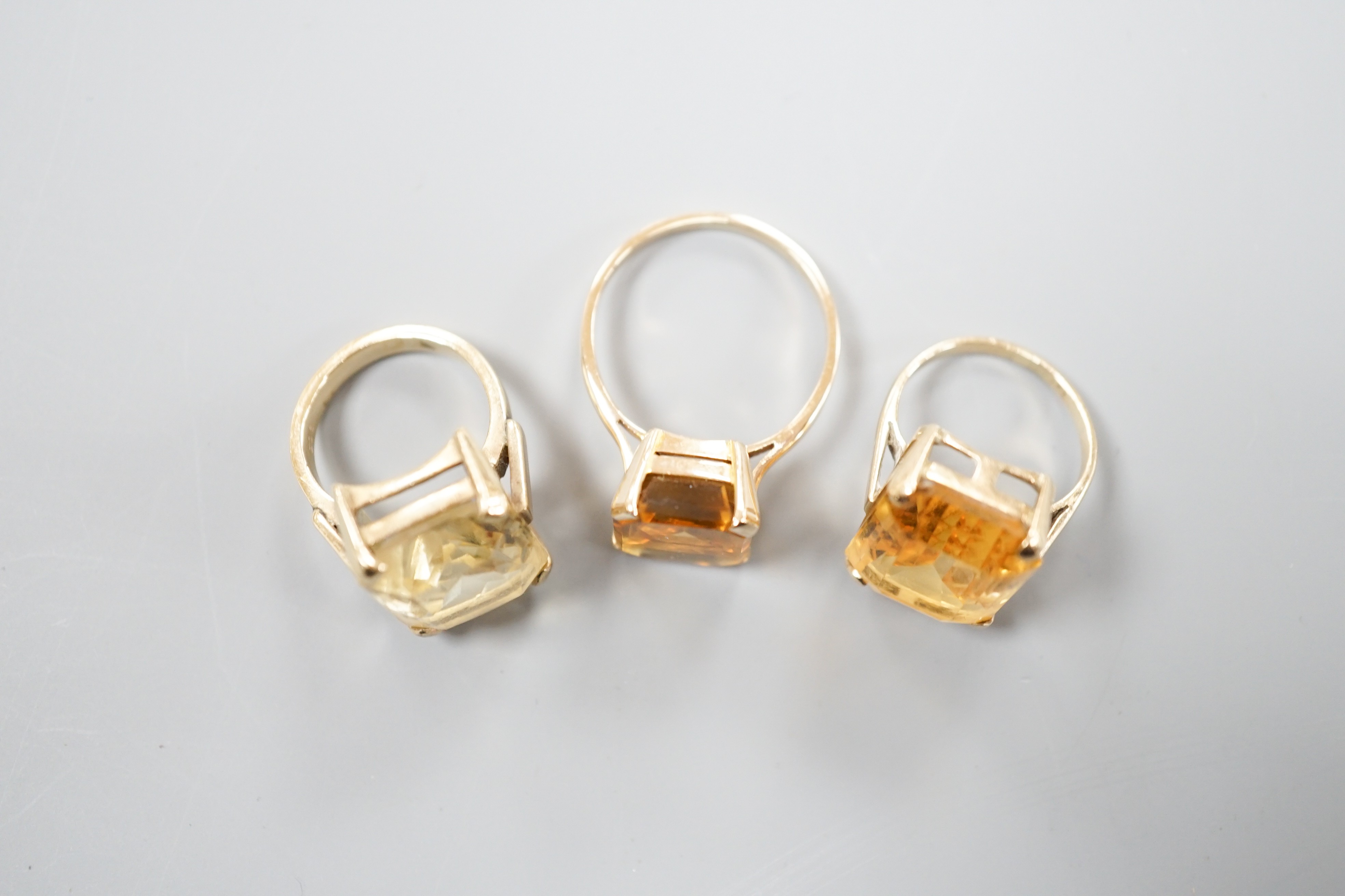 Three yellow metal and citrine set dress rings, one stamped 9ct, gross weight 11.9 grams.